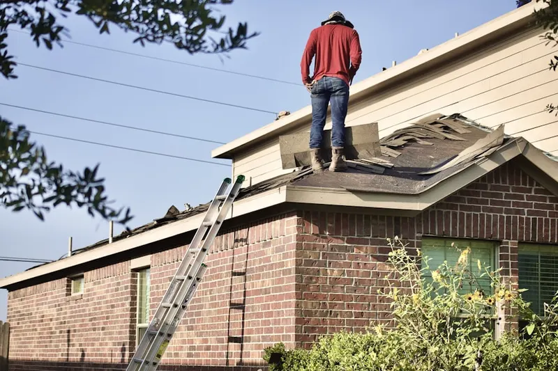 Professional roofer working on a residential roof in Piney Ridge Village